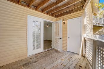 the deck of a home with a white door and a door to a hallway